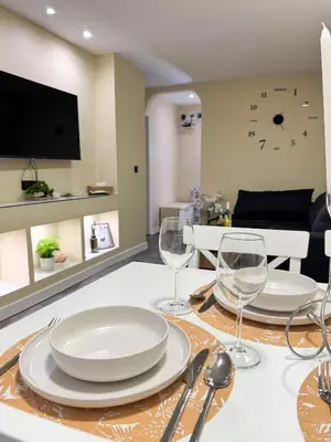 a dining table with plates and wine glasses on it at Top City Centre Apartment 122 in Sofia