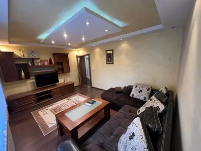 a living room with a couch and a tv at Къща Добринище in Dobrinishte