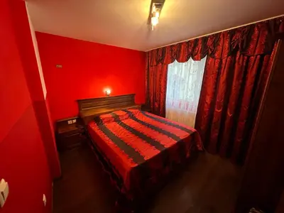 a red bedroom with a bed and a window at Къща Добринище in Dobrinishte