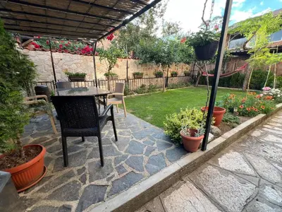 a patio with a table and chairs and plants at Къща Добринище in Dobrinishte