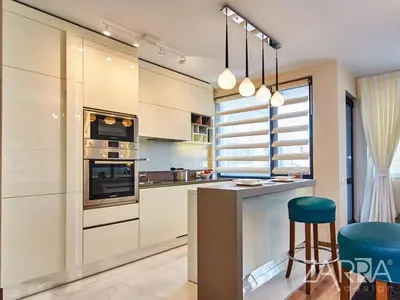 a kitchen with white cabinets and a blue stool at Apartment Braila in Plovdiv