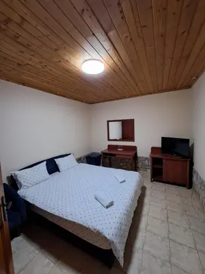 a bedroom with a bed and a wooden ceiling at Стария Чинар in Melnik