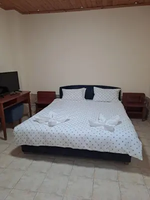 a bedroom with a bed with two white flowers on it at Стария Чинар in Melnik