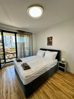 a bedroom with a large bed and a large window at D&G City Homes in Sofia