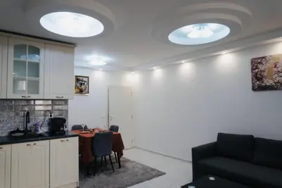 a kitchen with a table and two lights on the ceiling at Top Central Apartment 2 in Sofia
