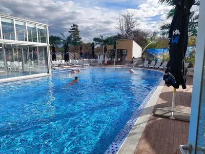 a large swimming pool with people in the water at Hotel Royal Bath in Banya