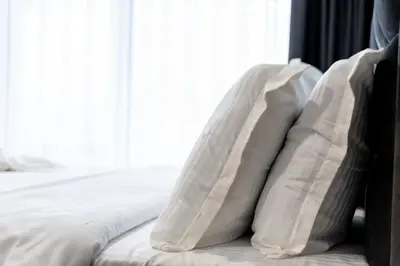 a pile of pillows on a bed with a window at Hotel Royal Bath in Banya