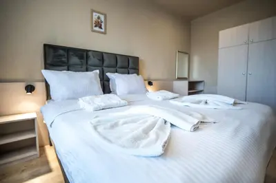 a large white bed with white towels on it at Hotel Royal Bath in Banya
