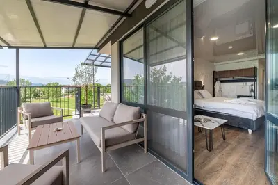 a room with a bedroom and a bed on a balcony at Hotel Royal Bath in Banya