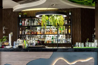 a bar with a black counter with alcohol bottles at Hotel Royal Bath in Banya