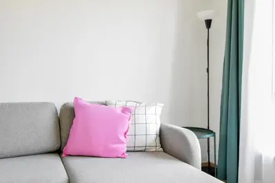 a pink pillow sitting on a couch in a living room at Scandinavian Charm - Central 1BD with Desk by Flat Manager in Sofia