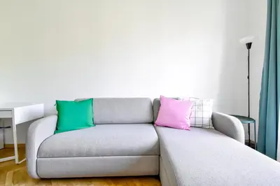 a gray couch with three colorful pillows on it at Scandinavian Charm - Central 1BD with Desk by Flat Manager in Sofia