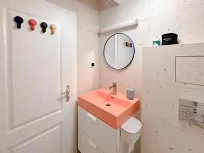 a bathroom with a pink sink and a toilet at Scandinavian Charm - Central 1BD with Desk by Flat Manager in Sofia