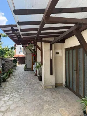 a wooden pergola on the side of a building at Къща за гости Гаджо Gadjo in Bansko