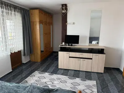 a bedroom with a desk with a television and a bed at Къща за гости Гаджо Gadjo in Bansko