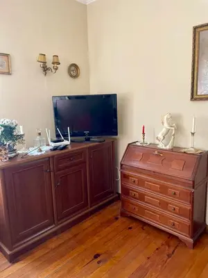 a living room with a flat screen tv and a dresser at Aristocratic Top Central Apartment in Sofia