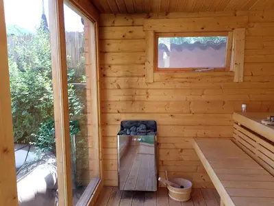 a wooden sauna with a bench and a window at Ma-Bebe PlayHouse with Private Sauna --- Lake, Parks and SPA Pools in 5 min in Pancharevo
