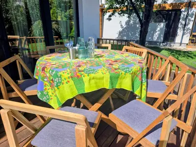 a table with a colorful table cloth and chairs at Ma-Bebe PlayHouse with Private Sauna --- Lake, Parks and SPA Pools in 5 min in Pancharevo
