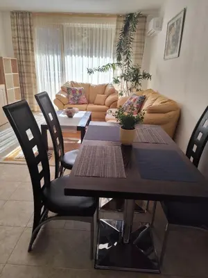 a dining room table with chairs and a couch at Guest House Amaya Riva in Plovdiv