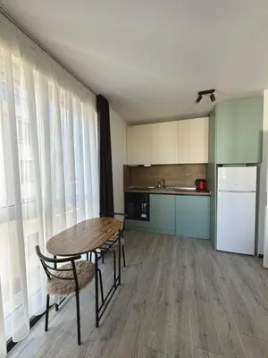 a kitchen with a table and chairs and a refrigerator at Stay Point One Bedroom Apartment Including Underground Parking Place in Sofia