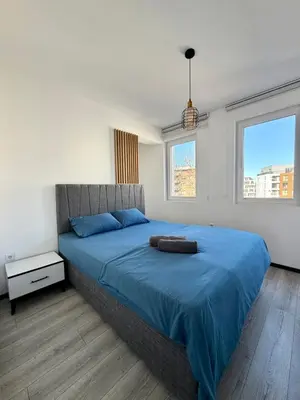 a bedroom with a large bed with a blue blanket at Stay Point One Bedroom Apartment Including Underground Parking Place in Sofia