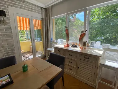 a kitchen with a wooden table and a table and windows at Journalist squad in Sofia