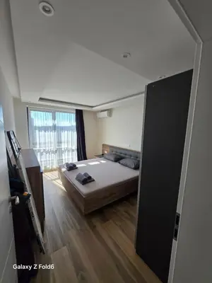 a bedroom with a bed and a large window at Dilyanka 3 in Pernik