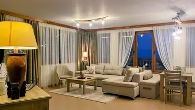 a living room with a couch and a table at Nature Escape to Pirin Golf in Razlog