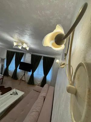 a living room with a couch and a ceiling fan at Just a Dream - guest apartments in Troyan