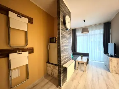 a room with a refrigerator and a tv in it at Flower house 1 in Sofia