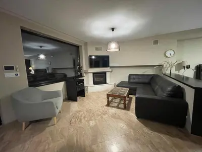 a living room with a black couch and a chair at Premium Studio Apartment in Private Villa Nisim in Batak