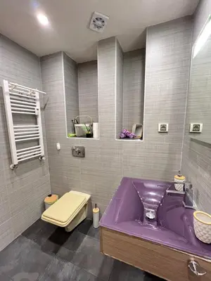 a bathroom with a purple tub and a toilet at Hamburg 100 Sq M 2BDR Family Apt near NDK and Vitosha BLVD in Sofia