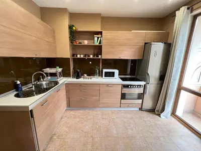a kitchen with wooden cabinets and a stainless steel refrigerator at Hamburg 100 Sq M 2BDR Family Apt near NDK and Vitosha BLVD in Sofia
