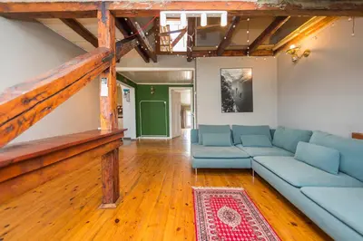 a living room with blue couches and a wooden floor at Cozy family loft at Women's market in Sofia