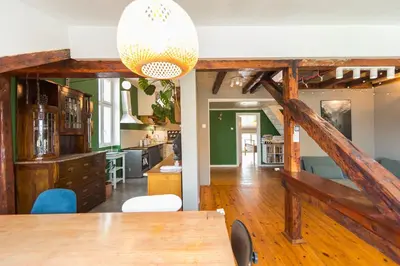 a living room with a table and a kitchen at Cozy family loft at Women's market in Sofia