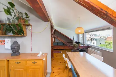 a dining room with a wooden table and a window at Cozy family loft at Women's market in Sofia