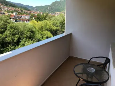 a balcony with a chair and a view of a city at Къща за гости Кристияна in Devin