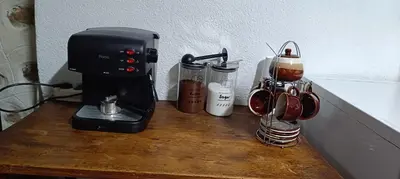 a coffee maker and cups on a wooden table at Къща за гости- Шале Мила in Bansko