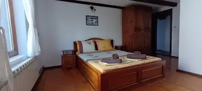 a bedroom with a bed with two towels on it at Къща за гости- Шале Мила in Bansko