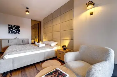 a bedroom with a bed and a chair at Luxury 1BD Retreat in Grand Resort Pamporovo by Flat Manаger in Pamporovo