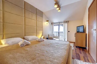 a bedroom with a large bed with towels on it at Luxury 1BD Retreat in Grand Resort Pamporovo by Flat Manаger in Pamporovo