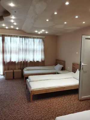a room with two beds and a window at Стаи за гости Деметра in Sofia