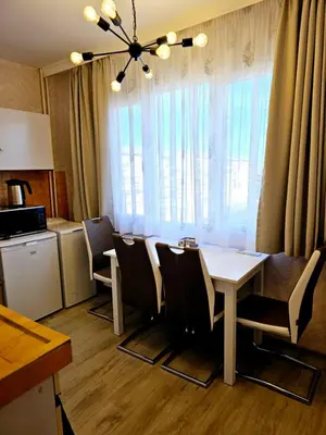 a dining room with a table and chairs and a kitchen at Ortakchiev 3 in Sofia