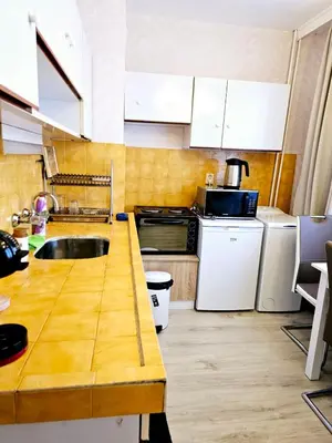 a kitchen with white cabinets and a wooden counter top at Ortakchiev 3 in Sofia