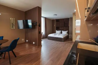 a hotel room with a bed and a table and a television at Home Lux in Gotse Delchev
