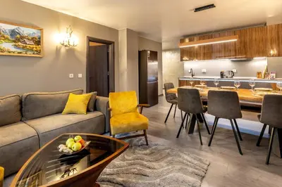 a living room with a couch and a table at Incredible 2BDR with Veranda and House-like Feel in Bansko