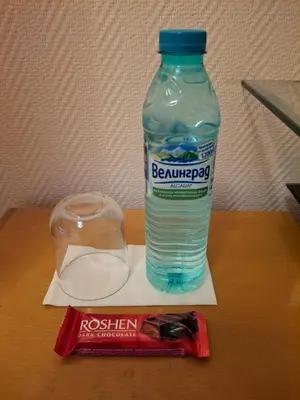 a bottle of water sitting on a table with a drink at Stay with Me Women only room parking childrens pets welcom in Sofia