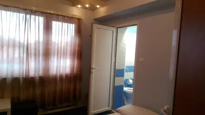 a room with a mirror and a door with a window at Стаи за гости Деметра in Sofia