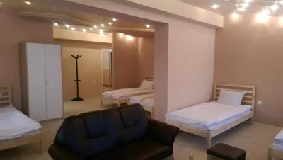 a living room with two beds and a chair at Стаи за гости Деметра in Sofia
