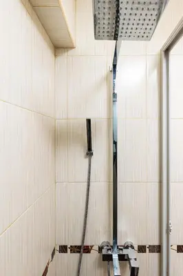 a shower in a room with white tile walls at Modern 2BD - 14 min to Medical University by Flat Manager in Plovdiv